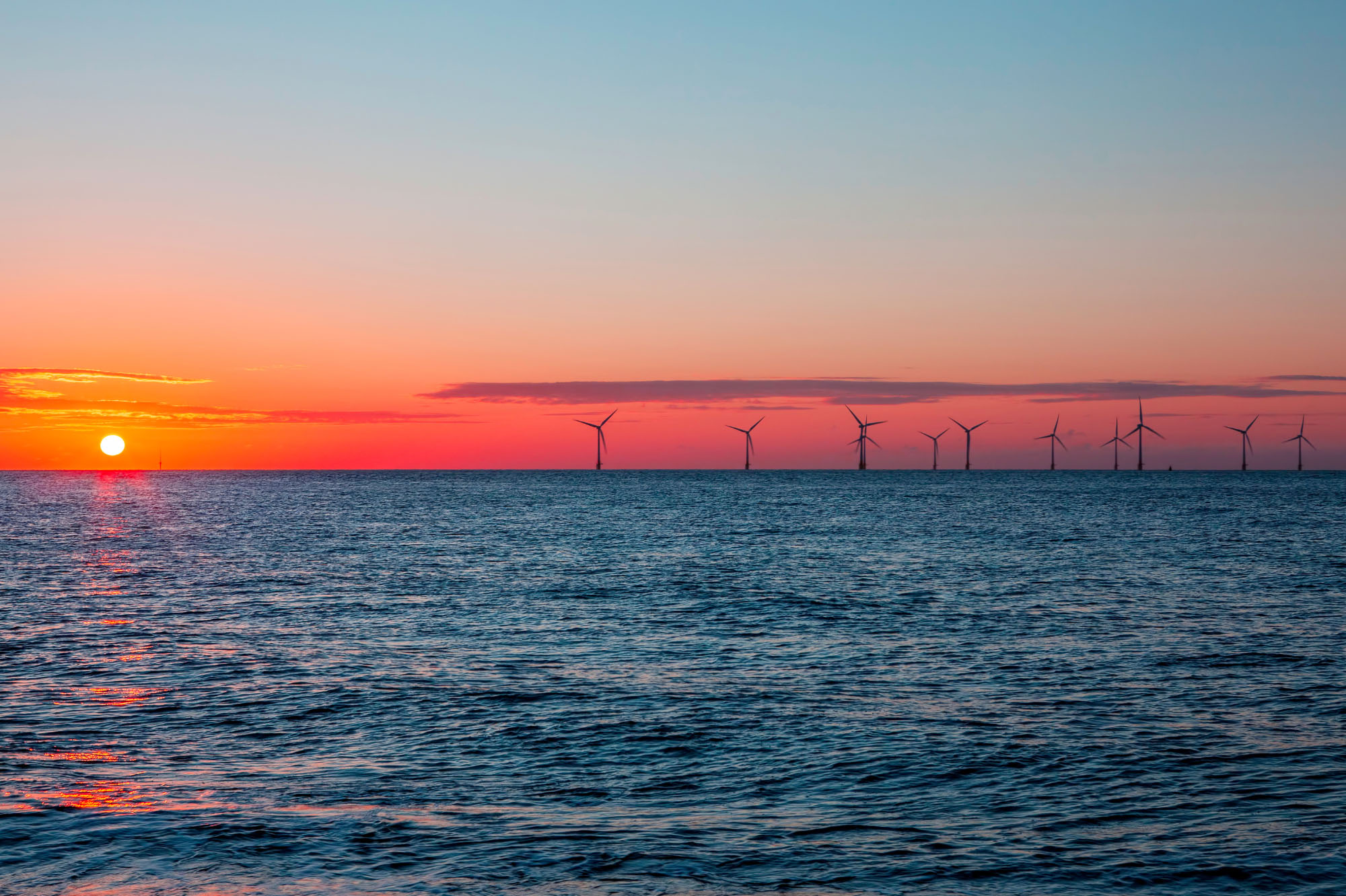 Sunset behind offshore wind farm