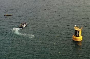 Marine data buoy and autonomous gliders being deployed into the ocean
