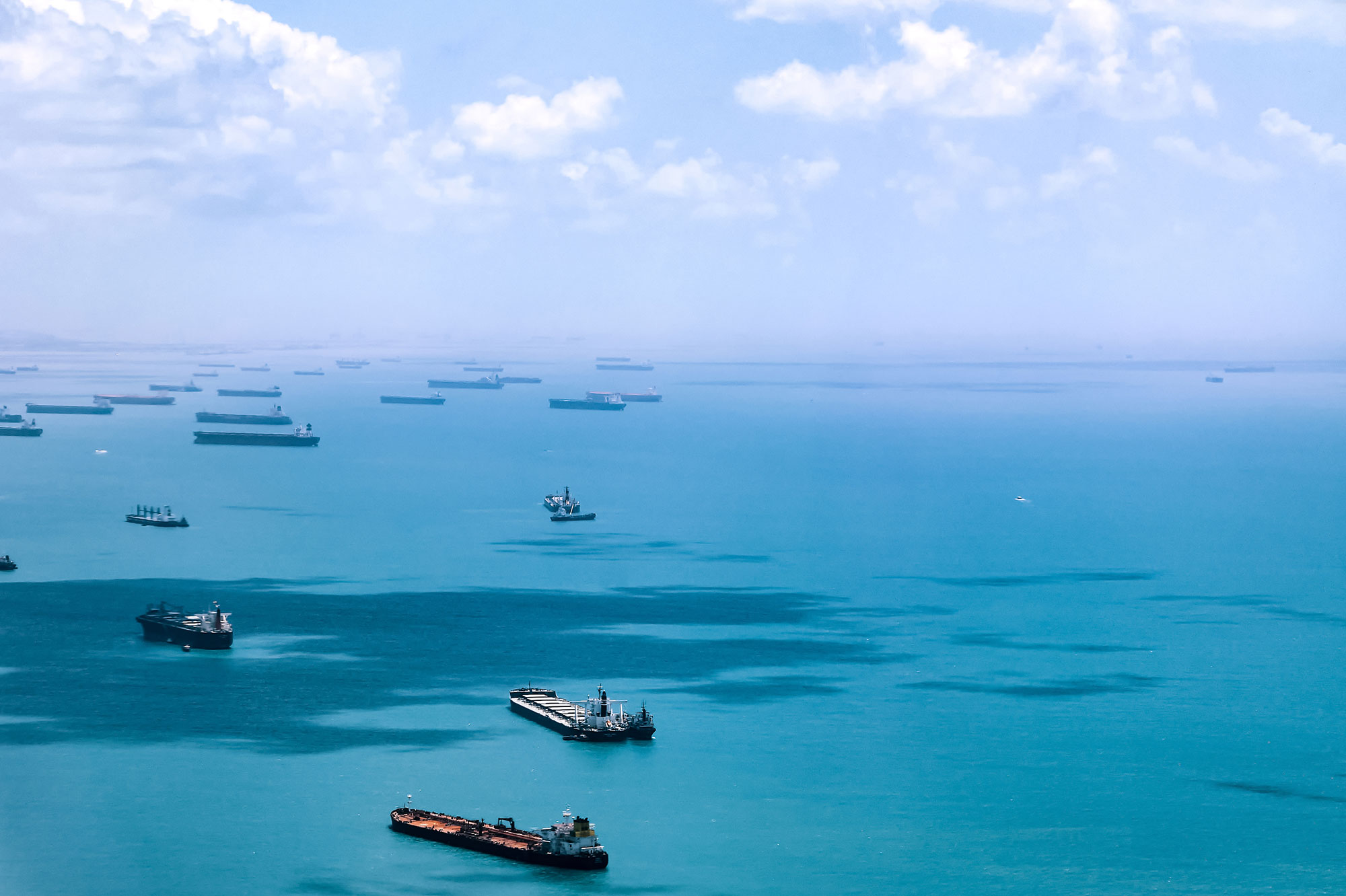 Container ships out in a bay with a vast stretch of ocean