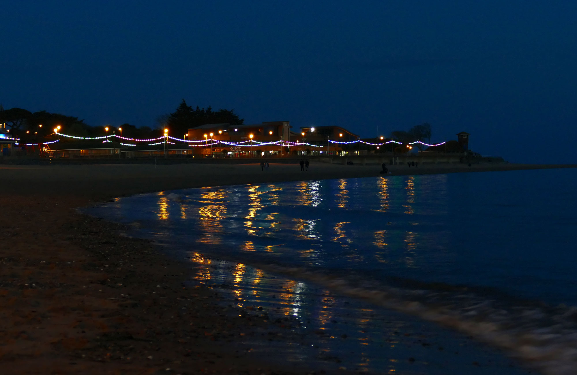 Sea front with artificial lights being reflected in the water